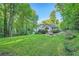 Expansive backyard with mature trees and a fire pit area, creating a serene outdoor space at 507 Falls Way, Woodstock, GA 30188