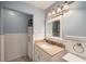 Well-lit bathroom featuring a granite countertop, stylish mirror, and white wainscoting at 507 Falls Way, Woodstock, GA 30188