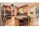 Kitchen features hardwood floors, granite countertops, stainless steel appliances, and stone accents at 507 Falls Way, Woodstock, GA 30188