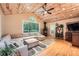 Inviting living room boasts a beamed wood ceiling, large window, hardwood floors, and comfortable seating at 507 Falls Way, Woodstock, GA 30188