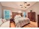 Serene main bedroom featuring wood headboard, a ceiling fan, hardwood floors, and natural light at 507 Falls Way, Woodstock, GA 30188