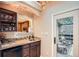 Stylish wet bar with granite counters, wood cabinets, sink, wine storage, and access to a patio at 507 Falls Way, Woodstock, GA 30188