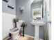 Bathroom featuring a pedestal sink, decorative mirror, and modern fixtures at 7244 Rockhouse Rd, Austell, GA 30168
