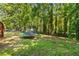 Large backyard with a shed, trampoline and mature trees at 1027 Spring Mill Sw Dr, Lilburn, GA 30047