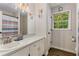 Charming bathroom with a white vanity, framed mirror, and a window offering natural light at 1027 Spring Mill Sw Dr, Lilburn, GA 30047