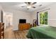 This bedroom offers wood floors, neutral walls, a dresser, and natural light from the window at 1027 Spring Mill Sw Dr, Lilburn, GA 30047