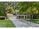Beautiful two-story home with lush trees, attached garage, and a quaint front porch at 1027 Spring Mill Sw Dr, Lilburn, GA 30047