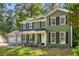 Well-maintained two-story home showcasing a welcoming front porch, classic shutters, and lush landscaping at 1027 Spring Mill Sw Dr, Lilburn, GA 30047