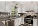 Updated kitchen with stainless steel appliances and stylish tile backsplash at 1027 Spring Mill Sw Dr, Lilburn, GA 30047