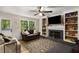Inviting living room featuring a fireplace, built-in shelving, ceiling fan and wood flooring at 1027 Spring Mill Sw Dr, Lilburn, GA 30047