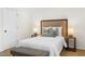 Modern bedroom features carpeted floor, neutral walls, headboard and lamps and gray bench at 1275 Muirforest Way, Stone Mountain, GA 30088