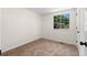 Bedroom features carpeted floor, neutral walls and trim, and window with green views at 1275 Muirforest Way, Stone Mountain, GA 30088