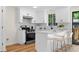 Modern kitchen with white cabinets, quartz countertops, stainless steel appliances, and a breakfast bar at 1275 Muirforest Way, Stone Mountain, GA 30088