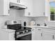 Modern kitchen features stainless steel appliances, white subway tile backsplash and white cabinets at 1275 Muirforest Way, Stone Mountain, GA 30088