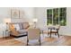 Bright living space with wood floors, neutral walls, and a view of the trees outside at 1275 Muirforest Way, Stone Mountain, GA 30088