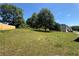 Large grassy backyard with a partial view of the house and surrounding trees under a bright blue sky at 3836 Wexford Dr, Douglasville, GA 30134
