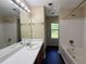 Bright bathroom with a shower-tub combo, white subway tile, and a large mirror at 3836 Wexford Dr, Douglasville, GA 30134