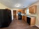 Functional kitchen featuring classic oak cabinets, black appliances, and vinyl floors at 3836 Wexford Dr, Douglasville, GA 30134