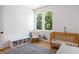 Sunlit Bedroom showcasing a cozy rocking chair, crib, shelving unit, and soft rug, creating a peaceful and stylish space at 53 Daniel Se St, Atlanta, GA 30312