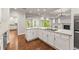 Modern kitchen with white cabinets, granite counters, an island cooktop, and stainless steel appliances at 5816 Chamblee Dunwoody Rd, Atlanta, GA 30338