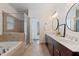 A well-lit bathroom with a double vanity, marble countertop, and tiled shower and floors at 1338 Dupont Nw Park, Atlanta, GA 30318