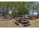 Community picnic area with wooden picnic tables, surrounded by mature trees and grassy space at 1338 Dupont Nw Park, Atlanta, GA 30318