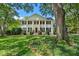 Classic white two-story home with columns, black shutters, and a lush green lawn at 2580 Hyde Manor Dr, Atlanta, GA 30327