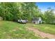 Large backyard featuring a white truck, a shed, and plenty of green space surrounded by mature trees at 39 Cannon Pl, Dallas, GA 30157