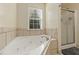 This bathroom showcases a tiled whirlpool tub with a shower behind a glass enclosure at 39 Cannon Pl, Dallas, GA 30157