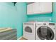 Laundry room features side-by-side washer and dryer, white cabinets, and tiled floor at 39 Cannon Pl, Dallas, GA 30157