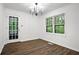Bright dining room with modern chandelier and large windows offering peaceful view to a lush and verdant forest at 6032 Lakeshore Se Dr, Mableton, GA 30126
