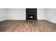 Large living room with wood-look flooring, a painted brick fireplace, and neutral paint at 6032 Lakeshore Se Dr, Mableton, GA 30126