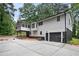 View of the home's rear elevation, showcasing the large deck, garage, and expansive concrete driveway at 6032 Lakeshore Se Dr, Mableton, GA 30126