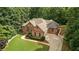 An elevated view of brick home highlighting the driveway, lawn, and mature surrounding trees at 7940 Gable Dr, Douglasville, GA 30135