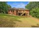 Backyard view of two-story brick home showing deck and lush green lawn with mature trees at 7940 Gable Dr, Douglasville, GA 30135
