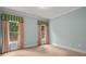 Bedroom with blue walls and two large windows with patterned curtains at 7940 Gable Dr, Douglasville, GA 30135