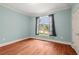 Bedroom with hardwood floors, large window and neutral blue paint at 7940 Gable Dr, Douglasville, GA 30135