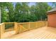 Large wooden deck with wood railings and a view of the treed backyard at 7940 Gable Dr, Douglasville, GA 30135