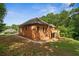 Brick home exterior with a lush green lawn, mature trees, and a wooden deck in a private backyard at 7940 Gable Dr, Douglasville, GA 30135