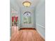 Bright foyer with hardwood floors, elegant light fixture, arched doorways, and soft blue walls at 7940 Gable Dr, Douglasville, GA 30135