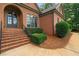 Close-up view of a charming brick home showcasing the arched entrance and manicured landscaping at 7940 Gable Dr, Douglasville, GA 30135