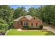 Charming brick home featuring an arched entry, manicured landscaping and a lush green lawn at 7940 Gable Dr, Douglasville, GA 30135