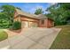 Side view of brick home with a three-car garage, long driveway and manicured landscaping at 7940 Gable Dr, Douglasville, GA 30135