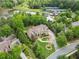 Aerial view showing a landscaped yard, mature trees, and circular driveway at 878 Middle Fork Trl, Suwanee, GA 30024