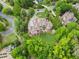 Aerial view showcasing an estate with mature trees, lush landscaping, and an expansive driveway at 878 Middle Fork Trl, Suwanee, GA 30024