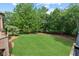 Well maintained lawn in backyard with a border of trees and plantings at 878 Middle Fork Trl, Suwanee, GA 30024