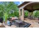 Outdoor patio with stone flooring, black metal fencing, comfortable seating, and view to backyard at 878 Middle Fork Trl, Suwanee, GA 30024