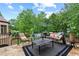 Outdoor patio features a stone floor, black metal fencing, comfortable seating, and lush backyard view at 878 Middle Fork Trl, Suwanee, GA 30024