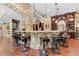 Unique basement bar area with a stone bar, saddle bar stools and custom built-in storage at 878 Middle Fork Trl, Suwanee, GA 30024