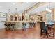 Custom home bar with unique saddle bar stools, stone accents, and hardwood floors at 878 Middle Fork Trl, Suwanee, GA 30024